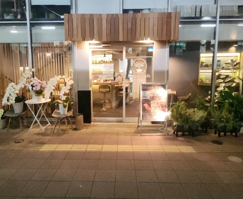 夜、木のひさしの照明が灯るGivers Cafeの外観