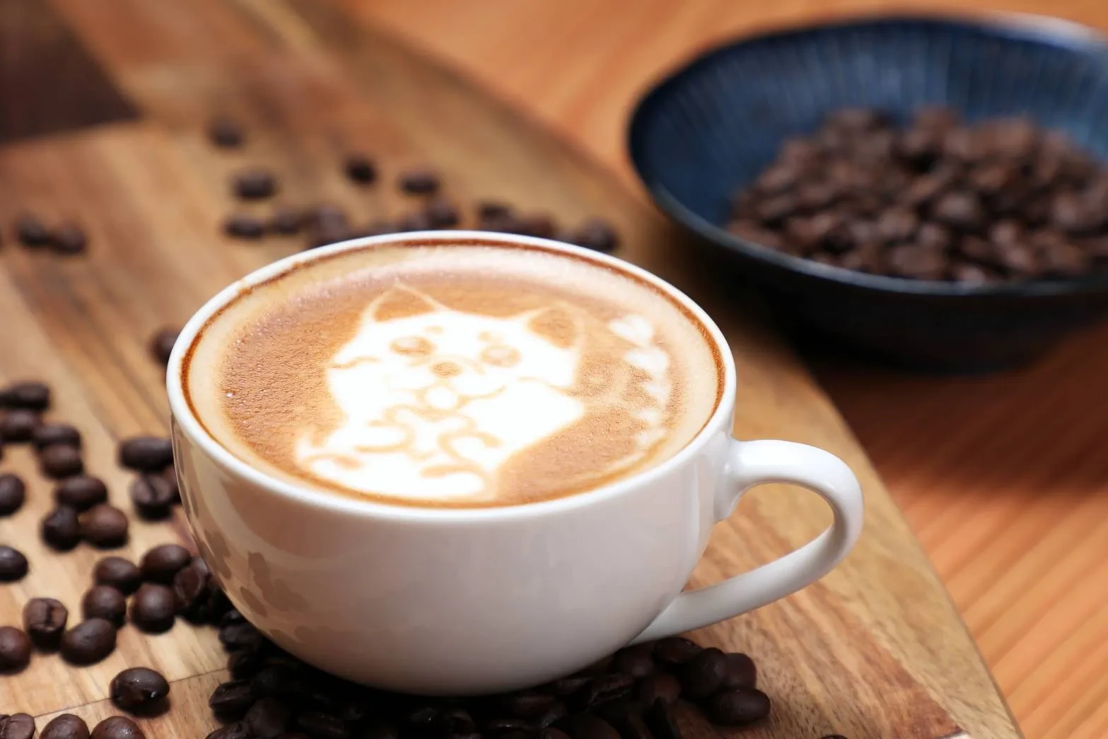 ラテアートを描いたカフェラテと、器に盛ったコーヒー豆