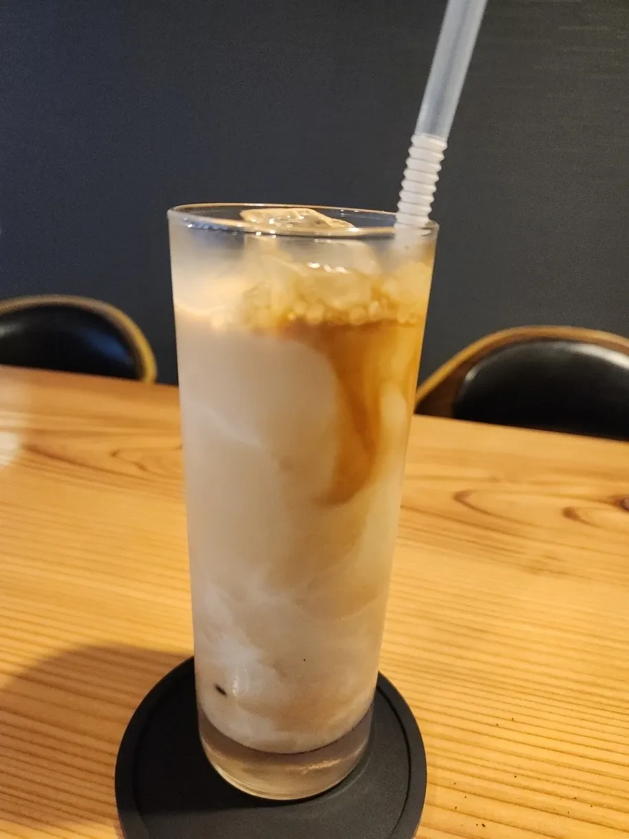 背の高いグラスに注いだアイスカフェラテ