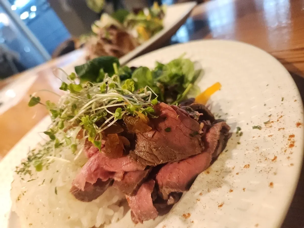 ローストビーフの丼ぶり。ごはんの上にローストビーフと葉野菜をのせた一皿